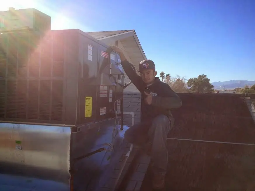 HVAC technician performing HVAC Inspection on a rooftop unit in White Lake